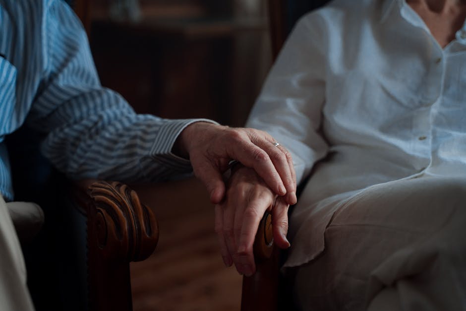 An intimate moment of an elderly couple holding hands, capturing love and companionship.