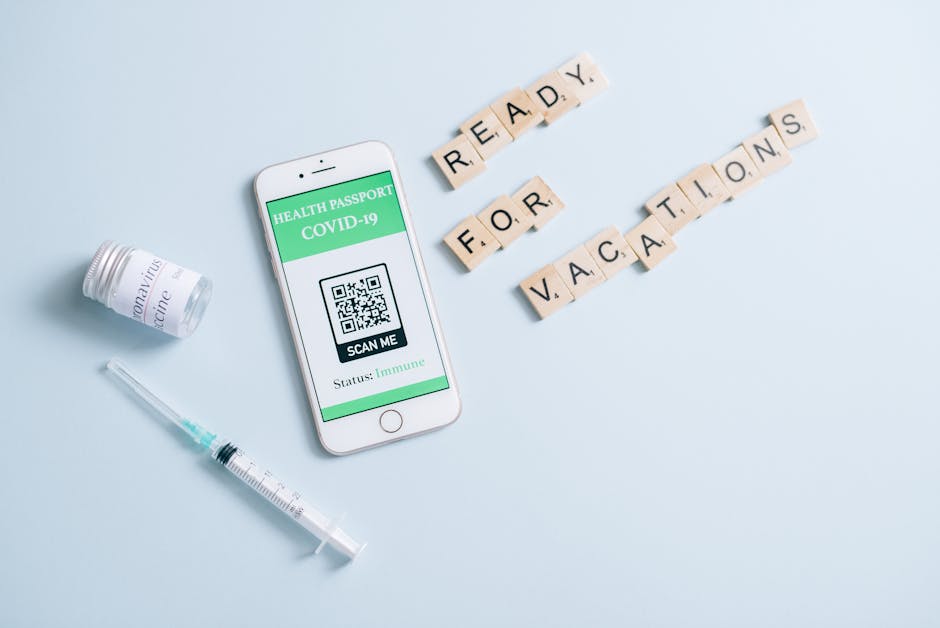 Smartphone displaying COVID-19 health passport with scrabble tiles spelling 'Ready for Vacations', vaccine vial, and syringe.