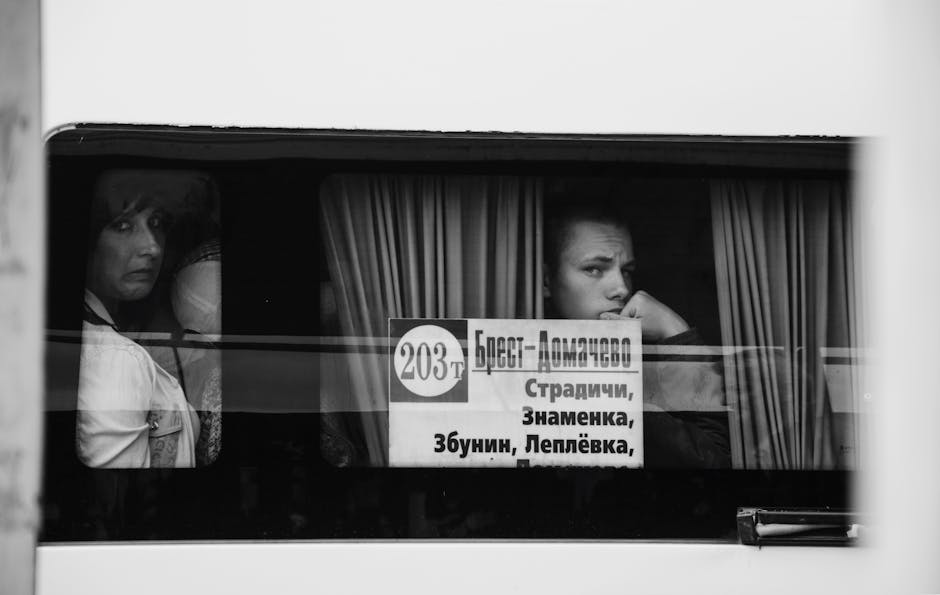 A black and white photo capturing thoughtful passengers gazing out a bus window.