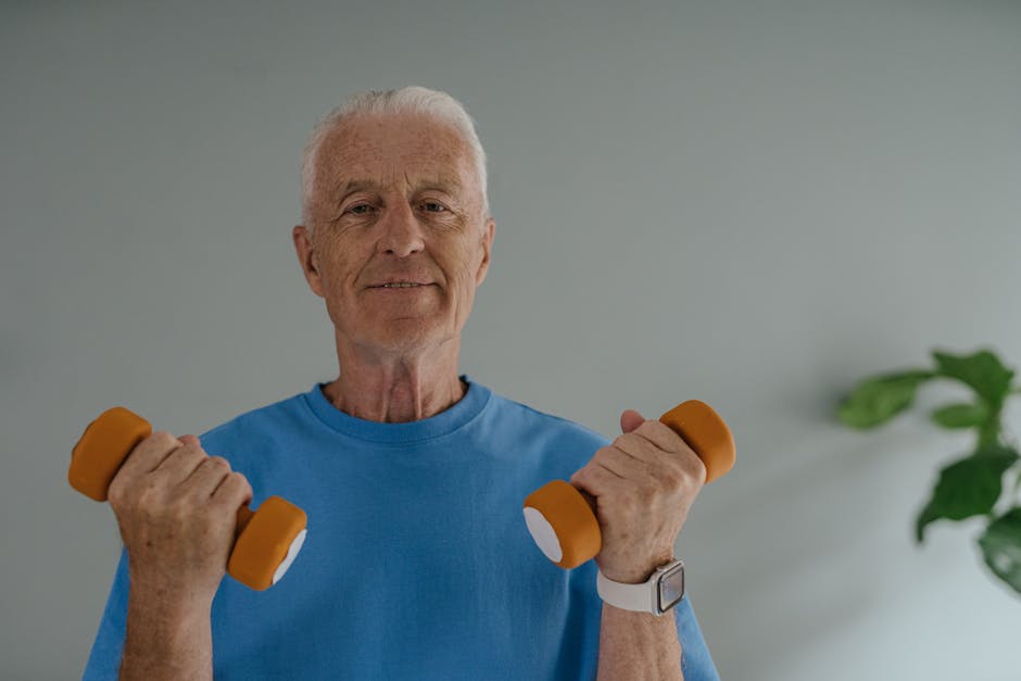 Elderly man in blue shirt lifting dumbbells and smiling indoors, promoting active lifestyle.