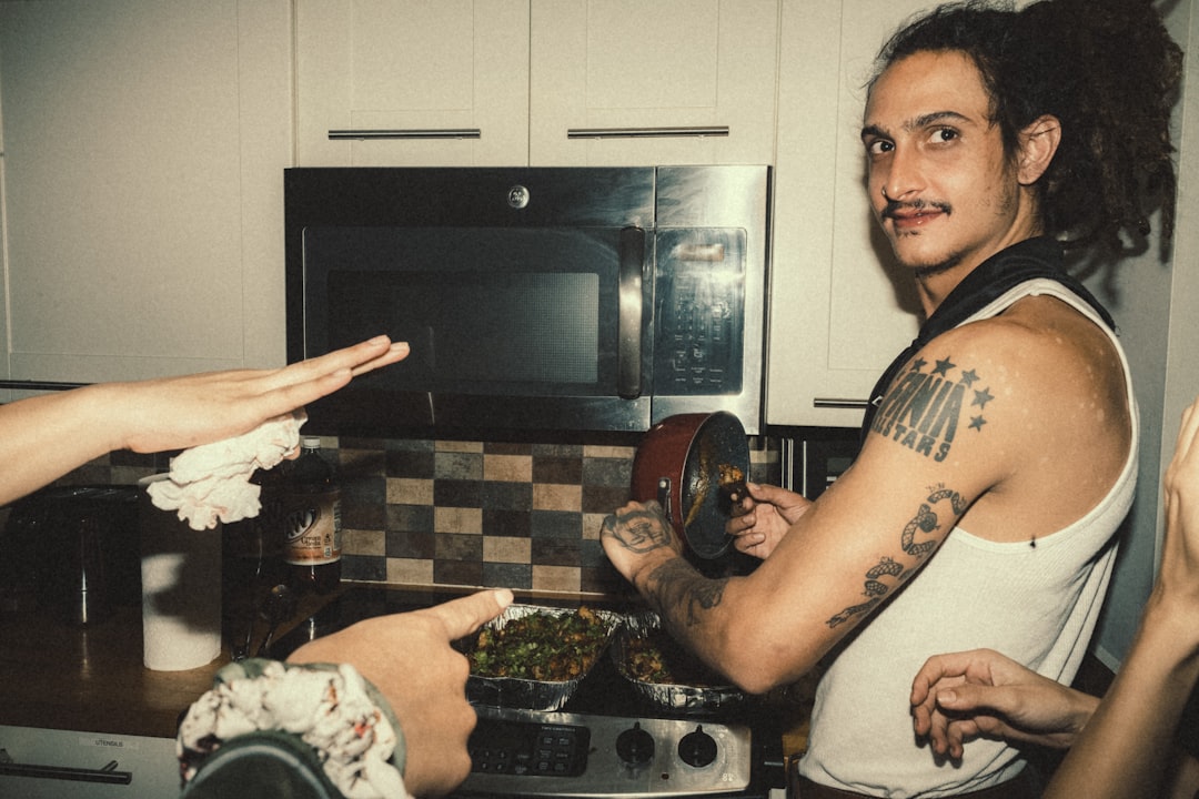a group of people standing around a stove in a kitchen